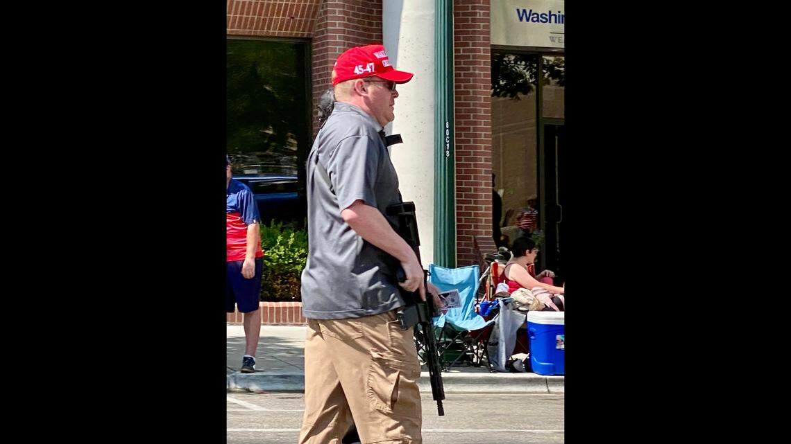 A members of the right-wing Idaho Liberty Dogs group carries a rifle as he walks in the Fourth of July parade in downtown Boise on July 4, 2023. The group’s inclusion in the parade drew criticism online.
