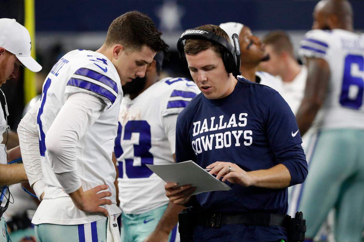 Dallas Cowboys offensive coordinator Kellen Moore, right, talks with quarterback Mike White, left, during the second half a preseason NFL football game in Arlington, Texas,in August.