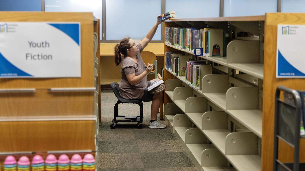 Youth Services Librarian Gabrielle Stoller works to organize books as they're taken off the shelves at the Meridian Library District Cherry Lane branch for renovations to the building, Aug. 14, 2025.