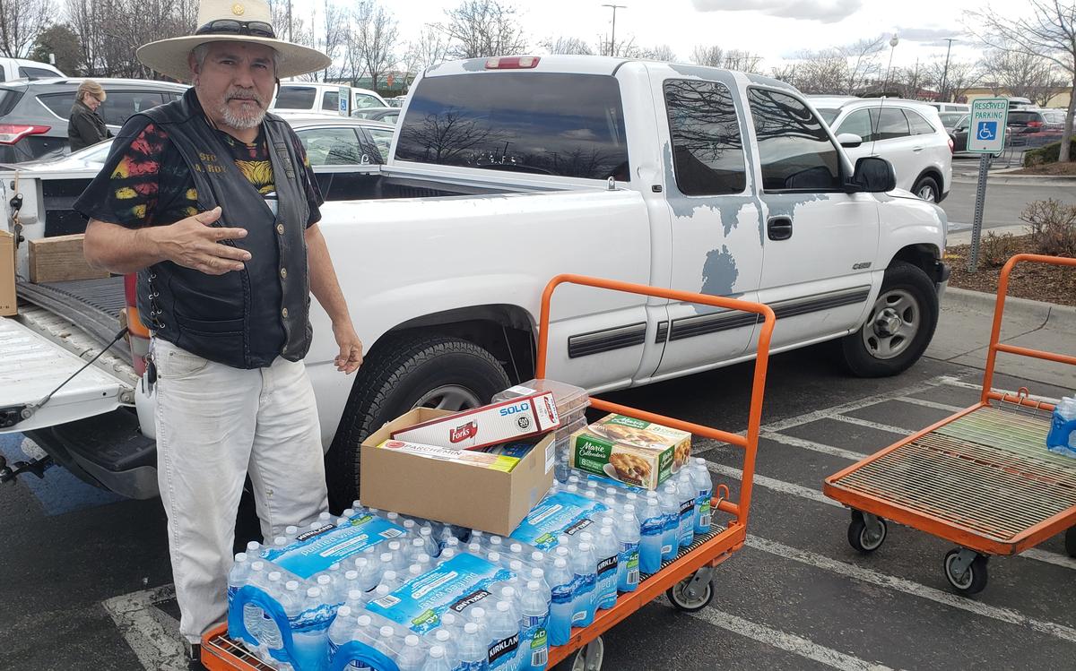 Roy Lemos unloads a dozen cases of drinking water the Boise resident bought at Costco on Tuesday. He was stocking up just in case there was a coronavirus diagnosis in the Boise area and stores began running out of products.