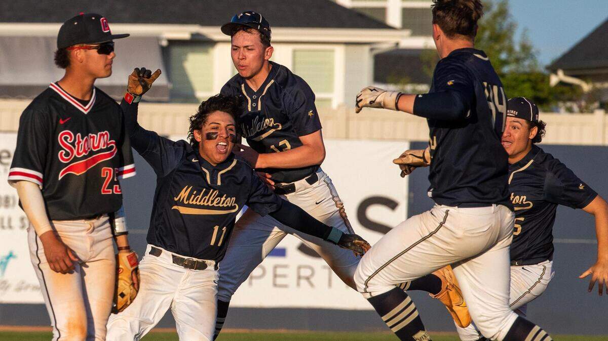 Middleton celebrates with Isaiah Anzaldua (11) after his walk-off single in the bottom of the seventh inning clinched the Vikings the 5A District Three baseball championship with a 6-5 win over Owyhee on Thursday at Middleton High.
