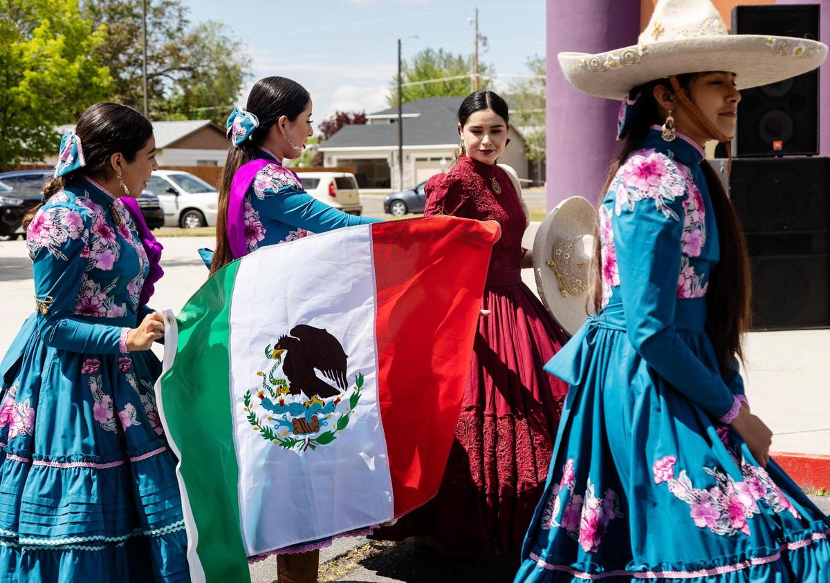 Women dressed in Escaramuza attire (a choreographed equestrian event) carry the Mexican flag at the inauguration ceremony.