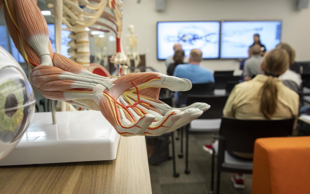 Visiting teachers gather in Idaho State University’s virtual reality anatomy and physiology classroom. The room features two state-of-the-art anatomage tables, which display 3-D digital anatomy, as well as more traditional models and reference books.