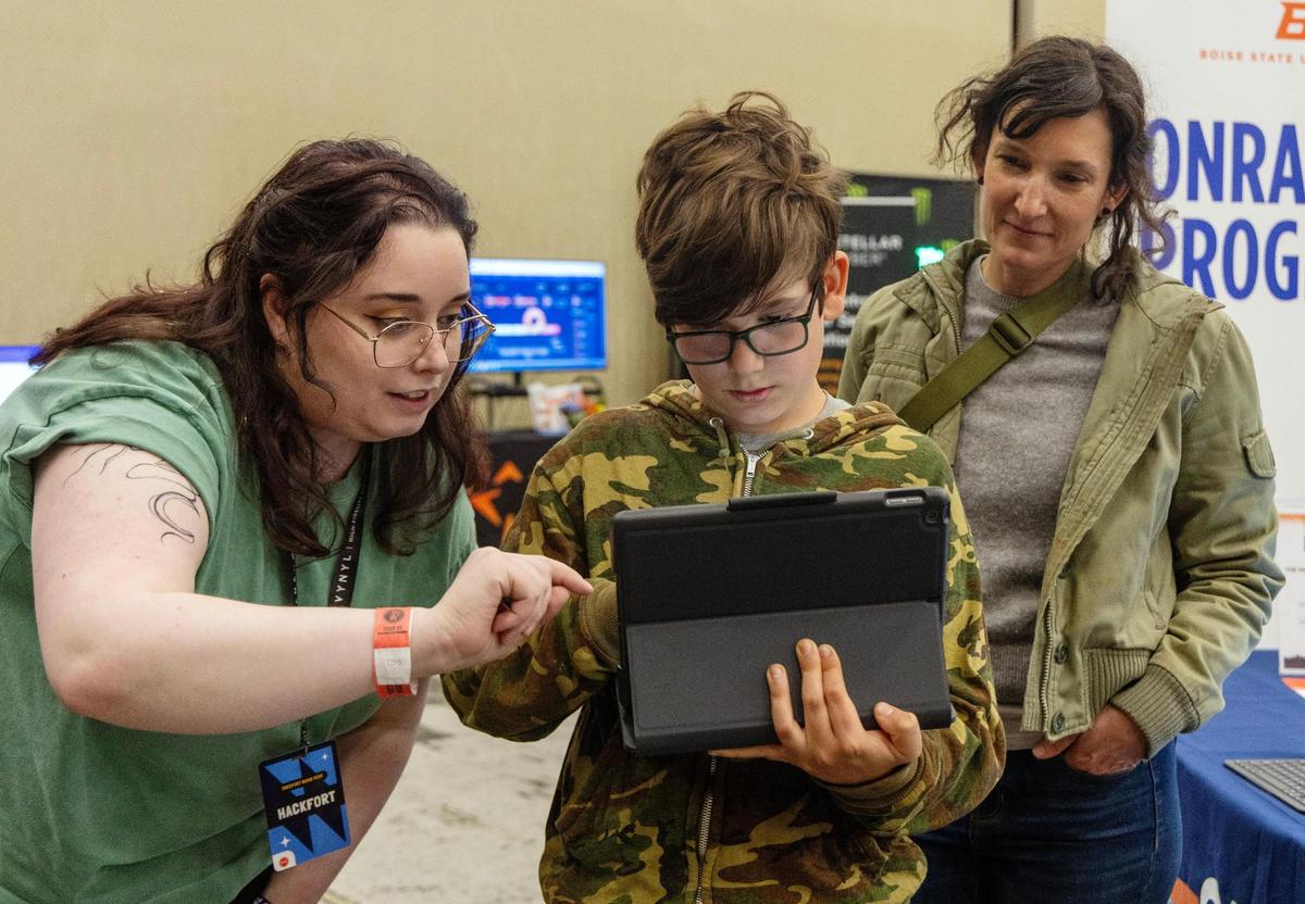 Onramp Program volunteer Emma DiNucci, left, helps Hackfort attendees Bertie Andreae, 10, of Boise, and his mother, Val Kiersig, create an augmented reality experience using a tablet at Hackfort on Thursday. Onramp Program is sponsored by Boise State University, College of Western Idaho, Idaho Digital Learning Alliance and Apple Community Education Initiative.