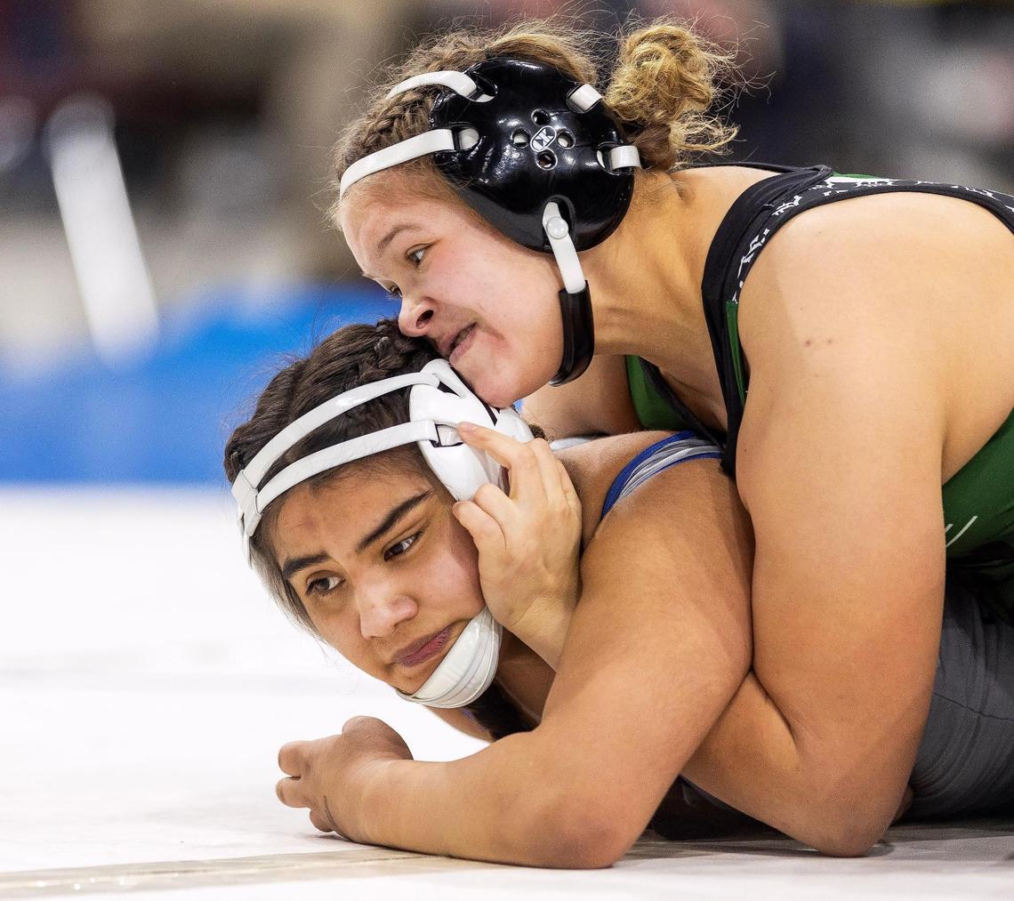 Eagle’s Reece Woods, top, pinned her way to back-to-back state titles Saturday, leading the Mustangs to the girls team title again.