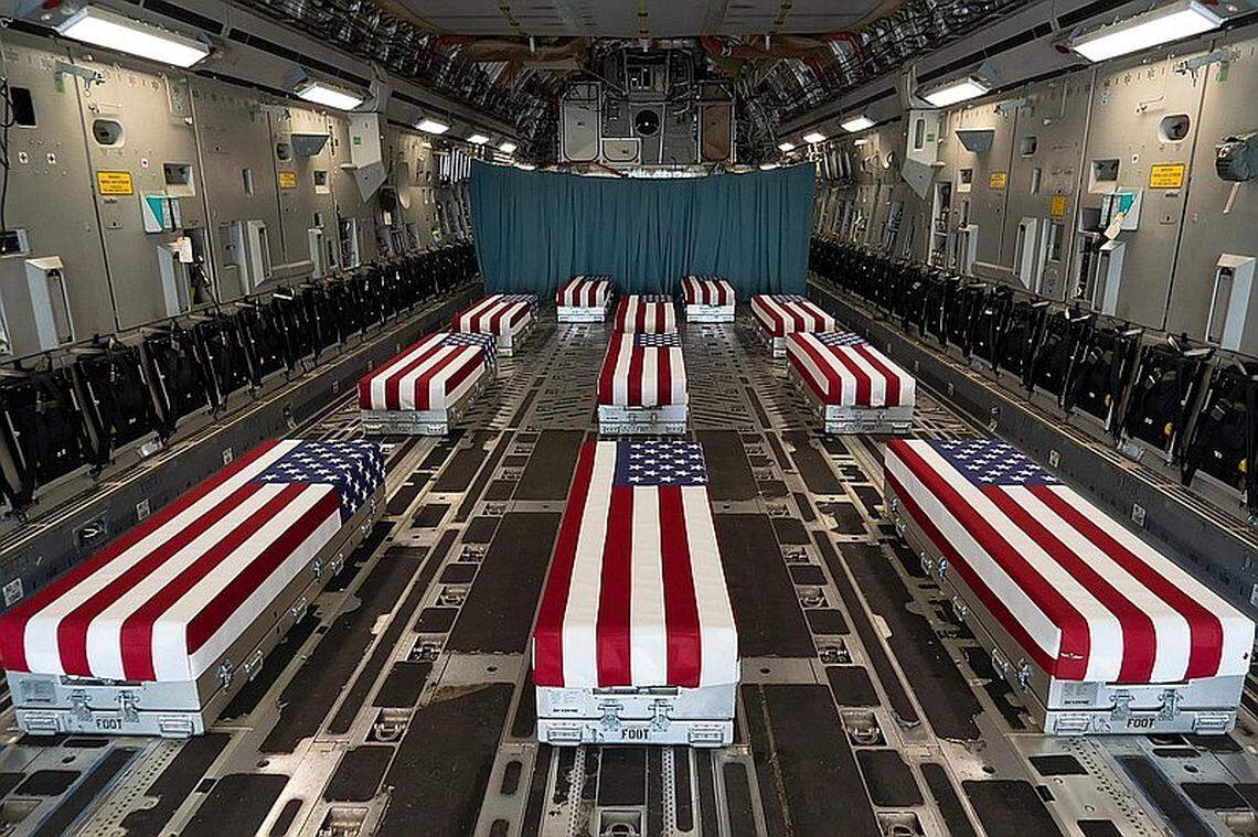 Flag-draped transfer cases carry the bodies of fallen service members who died in Afghanistan in August when a suicide bomber attacked the aiport in Kabul.