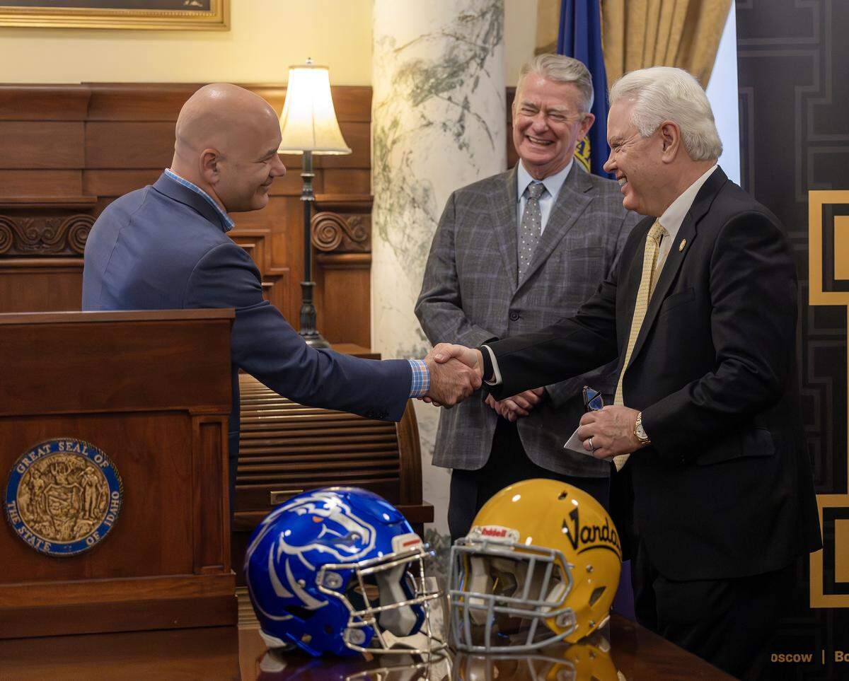 Boise State Interim President Dr. Jeremiah Shinn, left, shakes hands with University of Idaho President C. Scott Green, right, during a press conference at the Governor’s Office. 