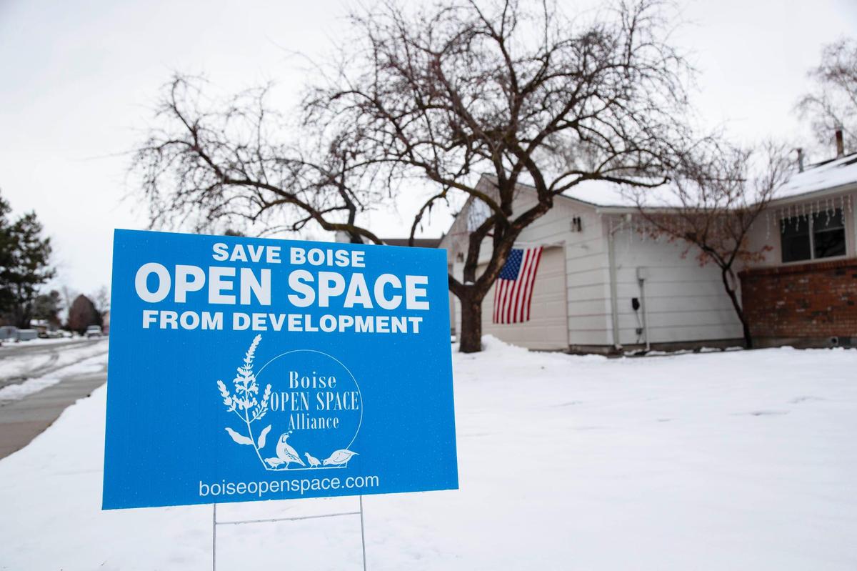 A home on Umatilla Avenue that backs up to permanent open land has a sign in its yard opposing changing the land zoning to allow development.