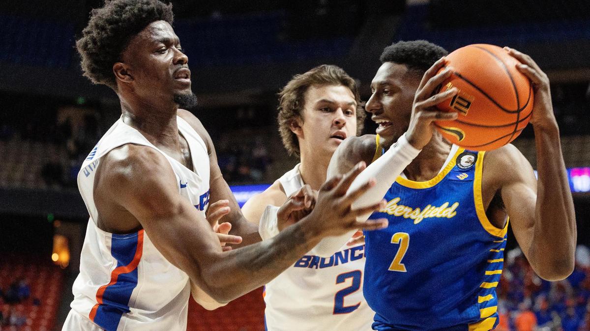 Boise State’s Devonaire Doutrive, left, and Tyson Degenhart try to get possession of the ball from Cal State Bakersfield’s Travis Henson. The Roadrunners upset the Broncos 46-39.