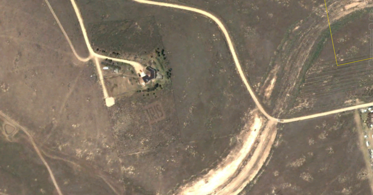 A Google Earth screengrab from June 2002 shows a message reading IRIS pruned into sagebrush at a Boise home across Interstate 84 from Micron. The sign, which Google measurements estimate was about 85 feet tall, was an advertisement for the homeowner’s flower business.