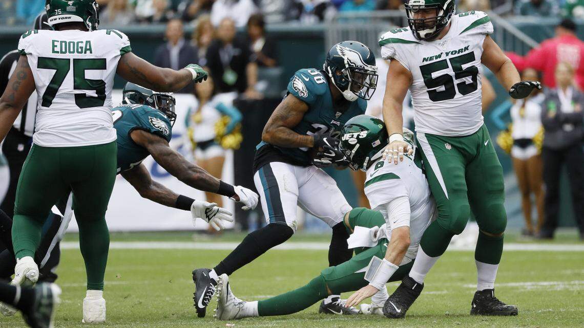 Philadelphia Eagles cornerback Orlando Scandrick, center, strips the ball from New York Jets quarterback Luke Falk after sacking him Sunday in a 31-6 victory. Scandrick returned the fumble for a touchdown.