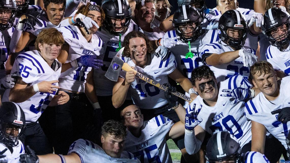 Rocky Mountain quarterback Tegan Sweaney, center, celebrates with the Battle of the Mountains rivalry trophy after beating Mountain View 37-21 on Friday at Mountain View High School.