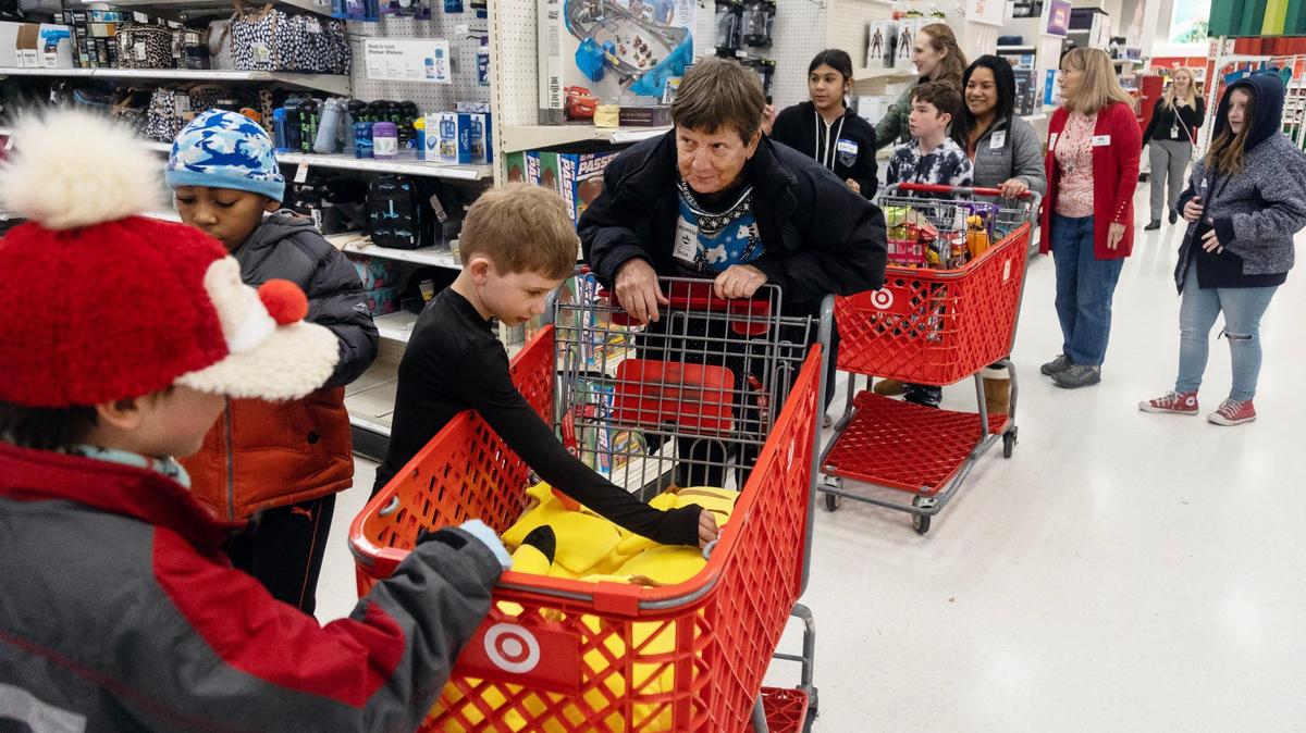Volunteer Tricia Matthews pushes the cart as JJ Agrrie, 8, front left, David Charles, 8, and Matthew Smith, 8, shop during the Boise Parks and Recreation Department’s Annual Kids Holiday Shopping Spree at Target on Eagle Road on Wednesday. Fifty volunteers chaperoned 172 students at the store in three time blocks. Each child had $40 to spend.