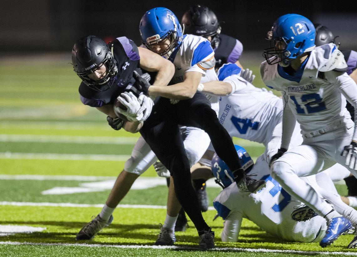 Rocky Mountain running back Jordan Erickson drags a host of Timberline defenders for a first down in last year’s 5A state quarterfinals.