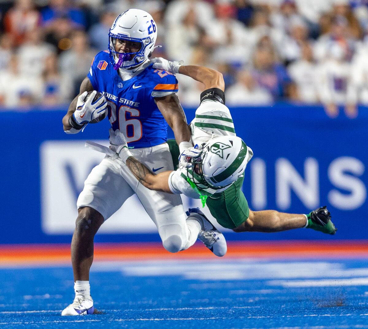 Boise State running back Sire Gaines stiff arms Portland State defensive back Zach Wusstig for a first down in the Broncos’ 2024 homeopener at Albertsons Stadium.
