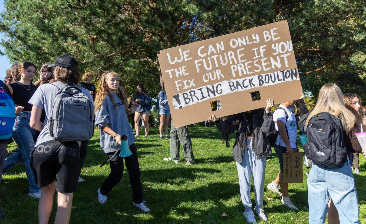 Timberline High School students stand on the sidewalk across the street from their school on Boise Ave. during a planned walkout in September 2023.