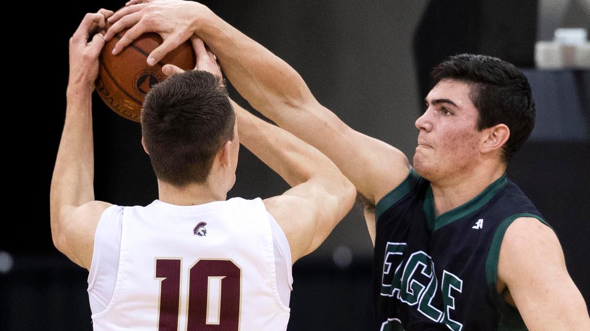 Eagle forward Jordan Kemp blocks a shot from Rigby’s Keegan Thompson in the first round of the 5A boys basketball state tournament Thursday at the Ford Idaho Center in Nampa.