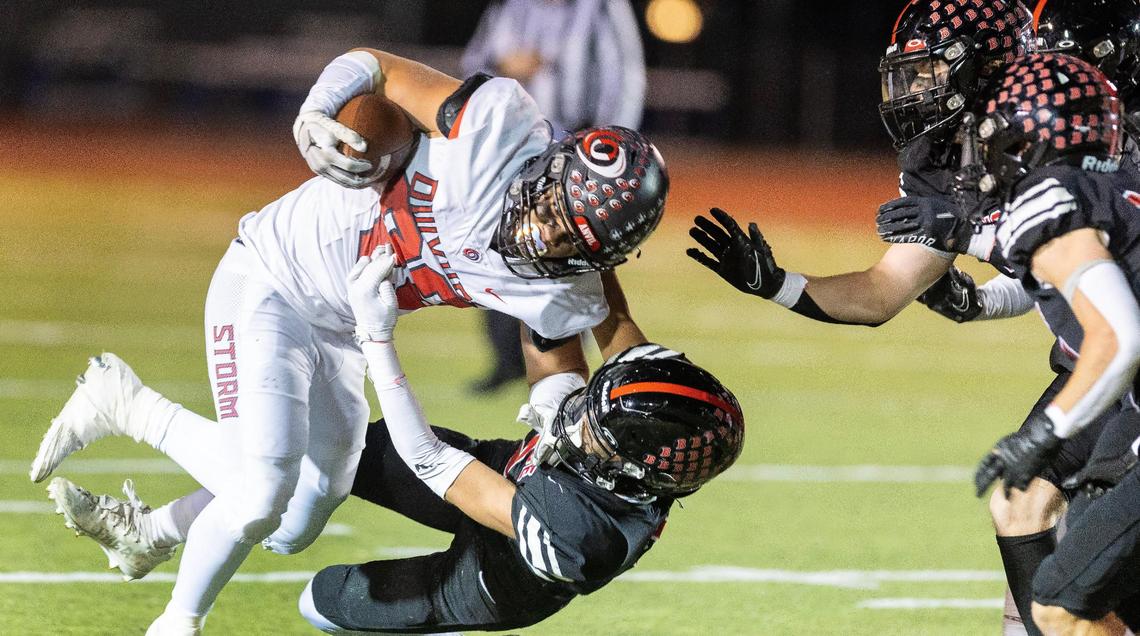 Owyhee junior running back Cade Walker is brought down by Boise senior defensive back Gus Arriola on Friday.