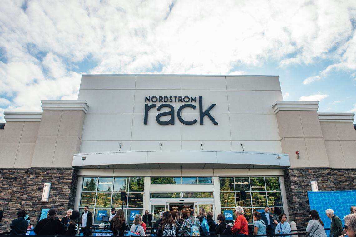 Shoppers stand outside a Nordstrom Rack.