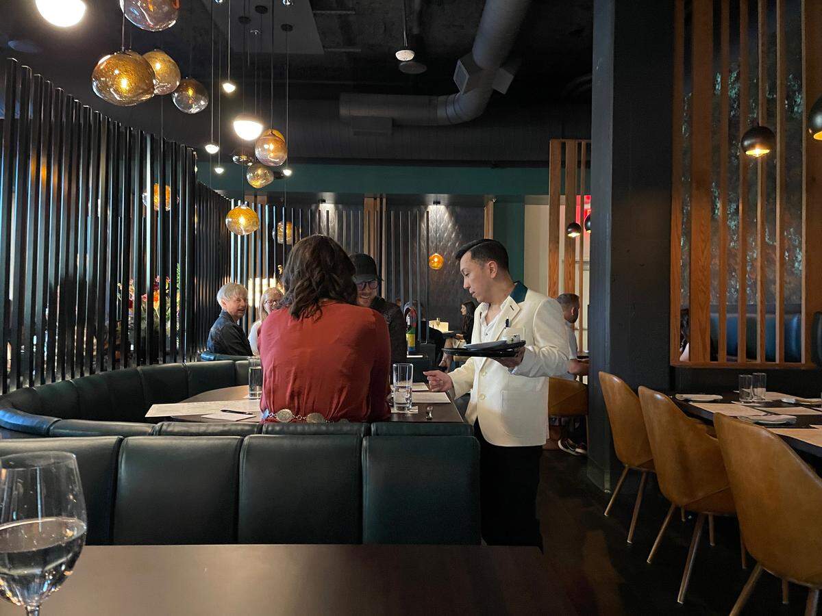 A server attends to guests during a preview dinner at Hemlock.