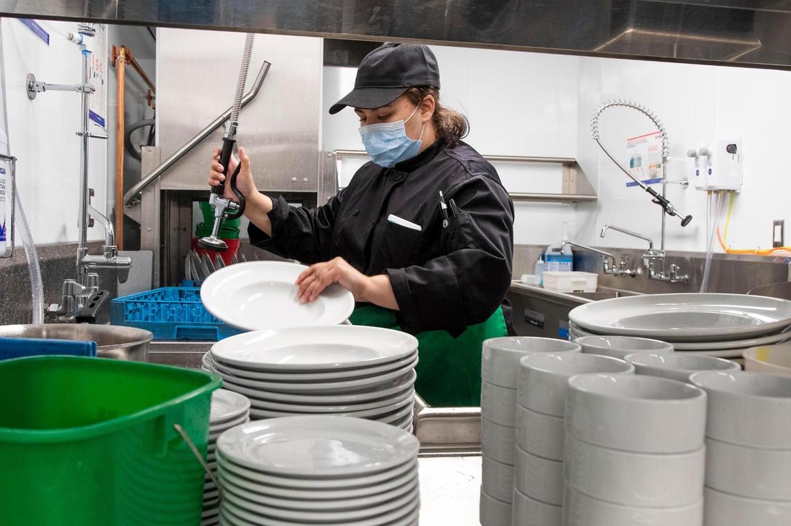 Regan Douglas, 21, washes new dishes as they are unpacked.