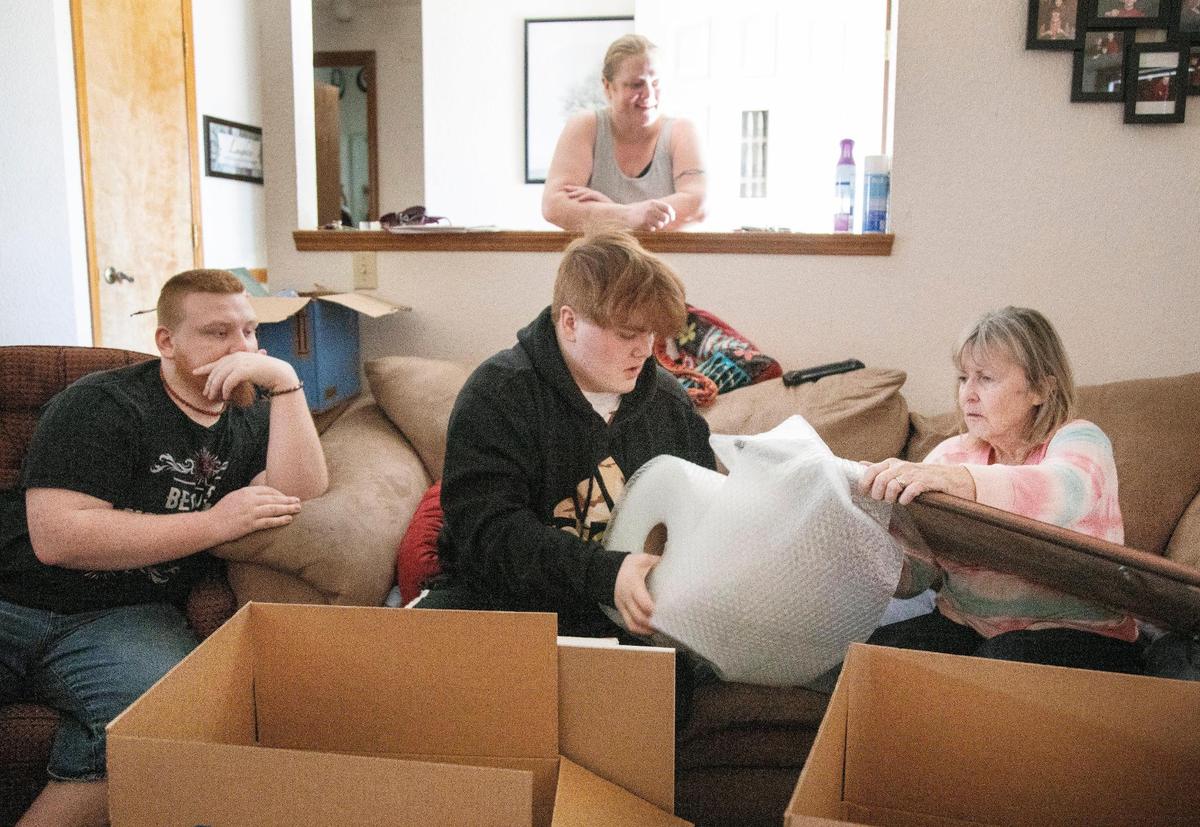 Tayden Thorne, 15, center, helps his grandmother Sharon Thorne, at far right, bubble wrap and pack a wall decoration. Tyler Thorne, 22, left, Teresea Thorne, background, and Tayden are preparing to leave their rental home of eight years without yet finding a new rental that will accept their housing-choice voucher.