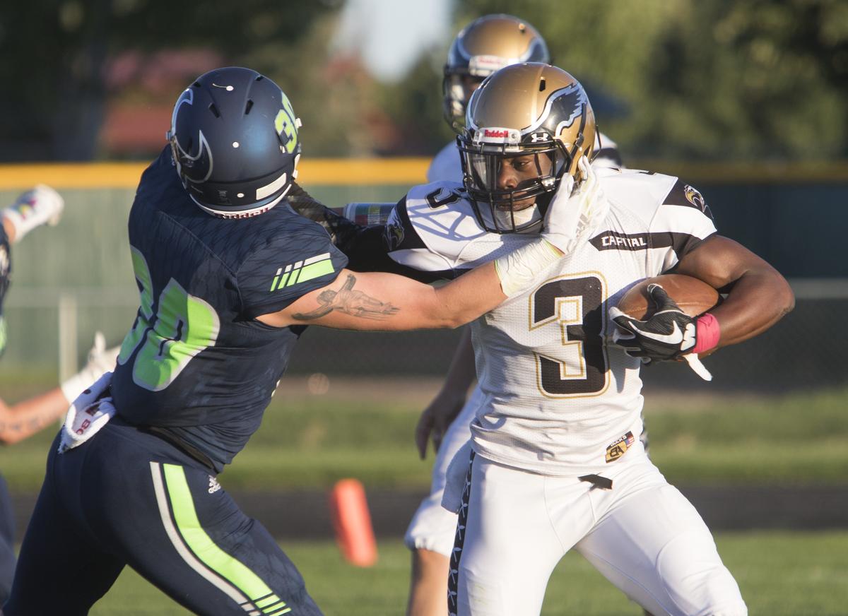 Capital’s Sam Sessou-Djokoto tries to break free from a tackle Friday at Mountain View.