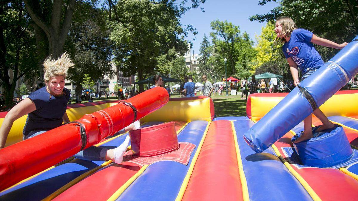 Alexandria Bandas (right) knocks down her mother, Nicole Nimmons (left), during a padded bar battle at the Feed Your Soul Fest held in 2017 at Capitol Park, now called Cecil D. Andrus Park. The Feed Your Soul Festival is a free outdoor festival in support of Create Common Good, which is a non-profit social enterprise for refugees, women escaping domestic violence, veterans and others to learn new skills, gain confidence and move into a place of self-sufficiency.