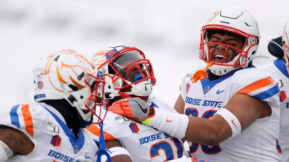 Boise State defensive back Tyreque Jones, center, celebrates intercepting a pass with cornerback Jalen Walker, left, and STUD end Curtis Weaver in the first half Friday at Colorado State.