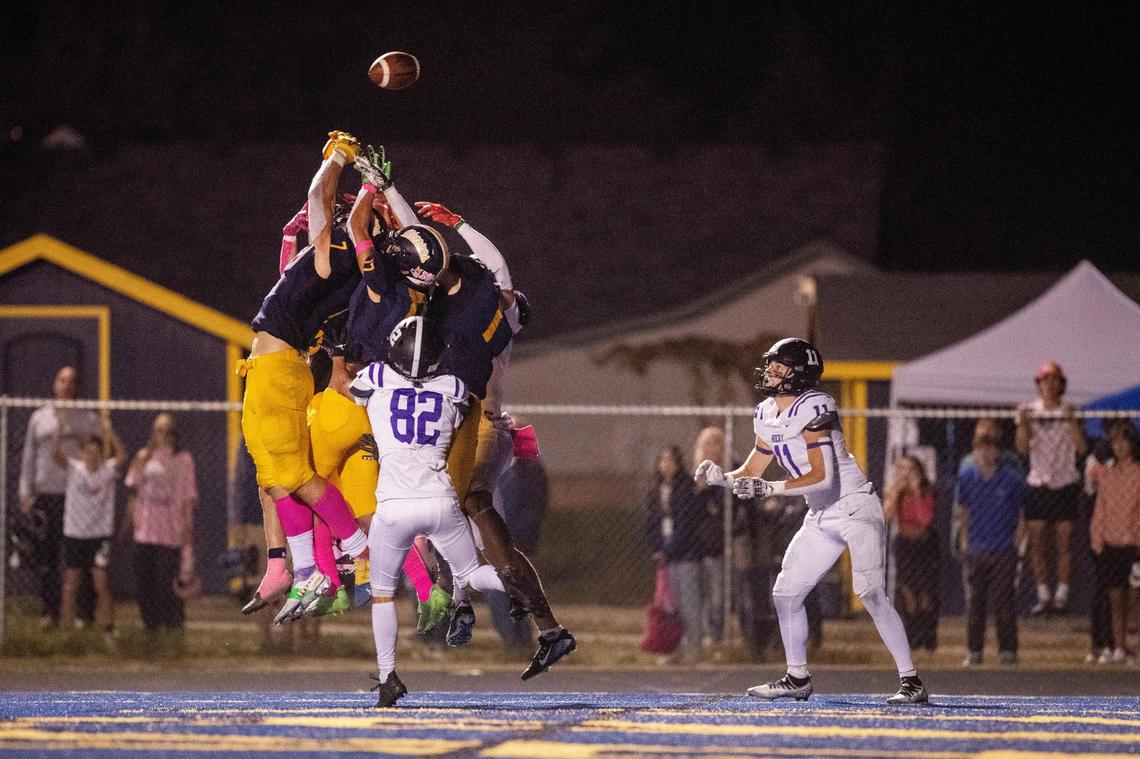 A tipped ball finds Rocky Mountain’s Luke Luchini, right, for a Hail Mary touchdown with 1 second left Friday at Meridian.