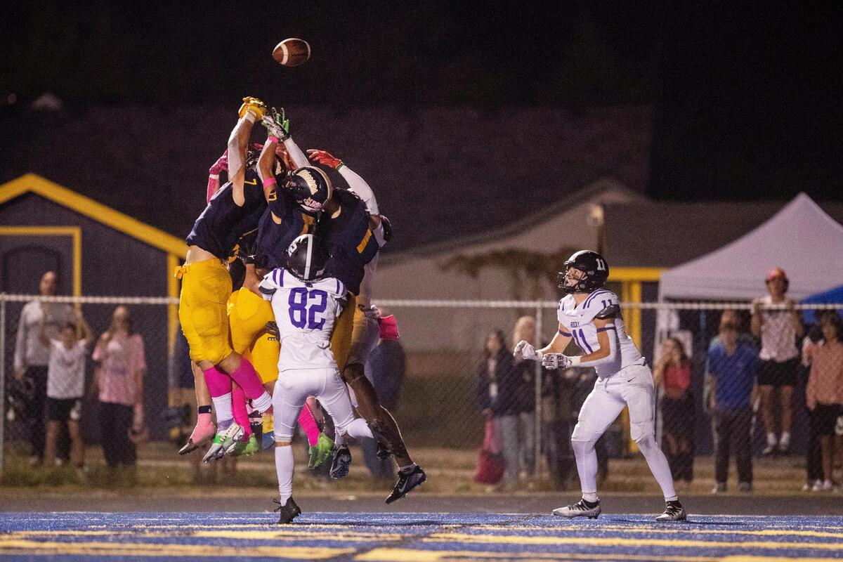 A tipped ball finds Rocky Mountain’s Luke Luchini, right, for a Hail Mary touchdown with 1 second left Friday at Meridian.