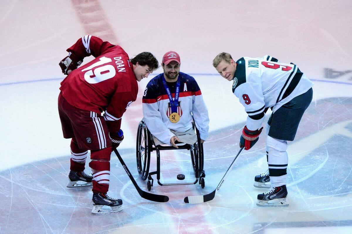Paralympian and gold medal winner Josh Sweeney drops the puck for a ceremonial face off between Phoenix Coyotes right wing Shane Doan, left, and Minnesota Wild center Mikko Koivu prior to a game in 2014 in Glendale, Arizona.