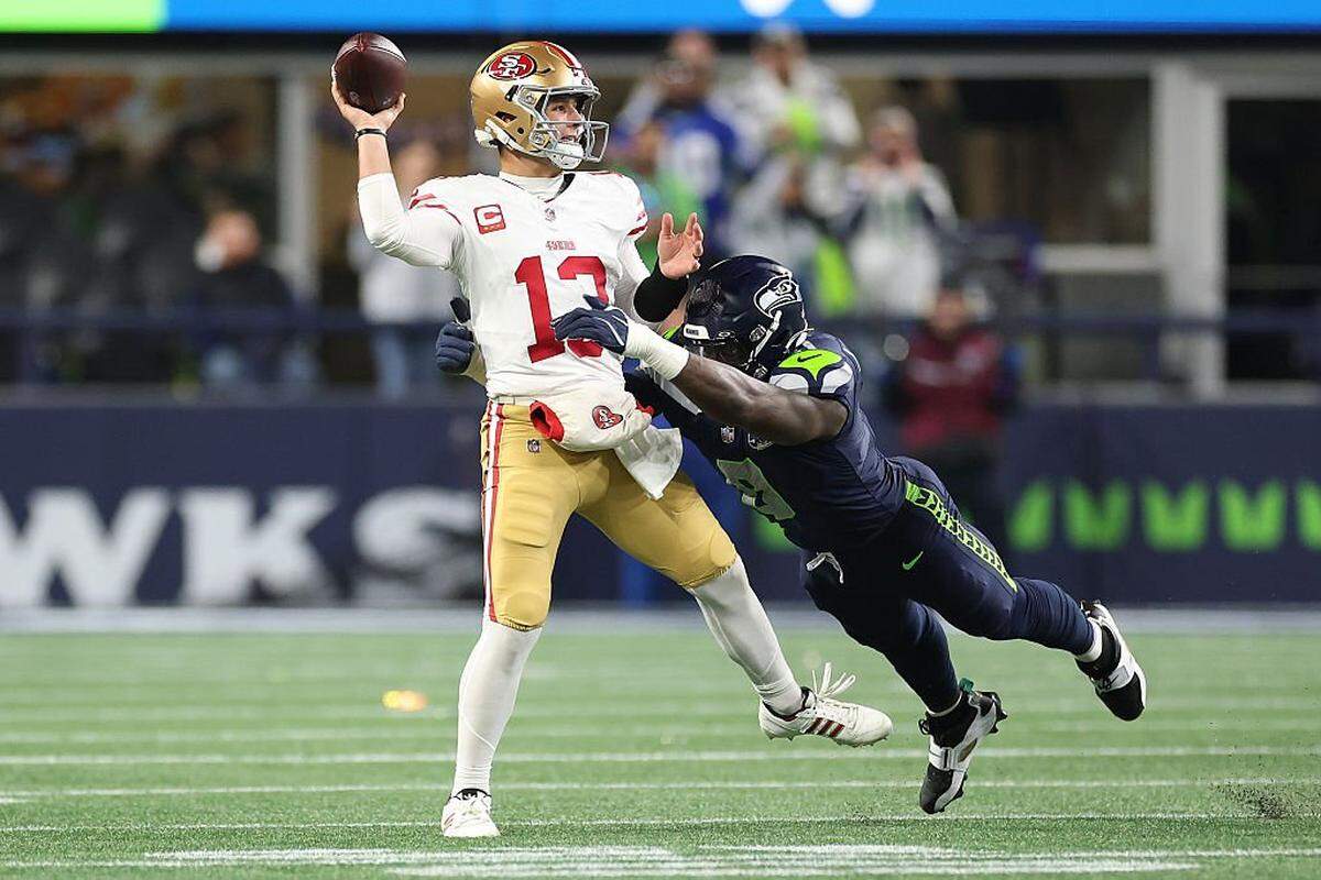 San Francisco quarterback Brock Purdy is pressured by Seattle’s DeMarcus Lawrence in their NFC divisional playoff game last weekend at Lumen Field in Seattle.