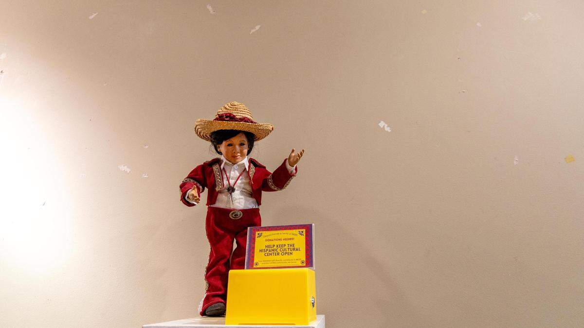 A doll stands in front of a blank wall that was once covered in art. The art was removed from a gallery inside the building the Hispanic Cultural Center of Idaho used to occupy after its management was ordered to leave.