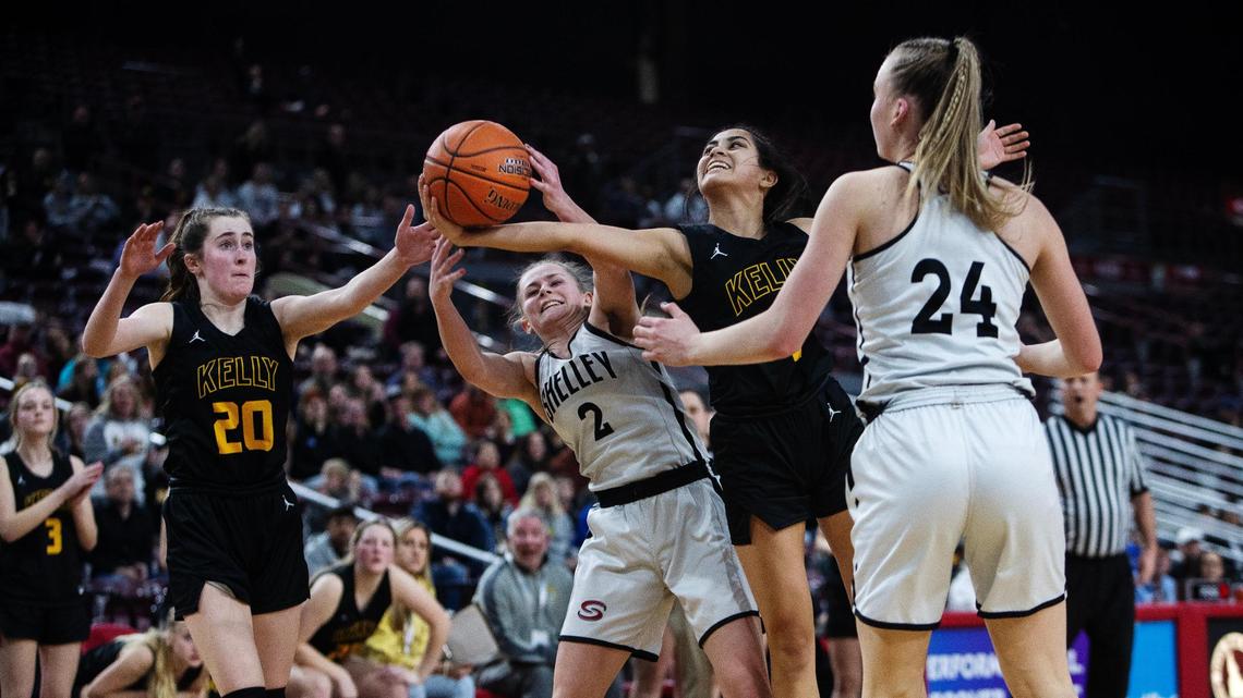 Bishop Kelly junior Keira Lizama grimaces as she tries for a basket but is foiled by Shelley senior Hallie Dye during the fourth quarter in the 4A girls basketball state semifinal game at Ford Idaho Center in Nampa.