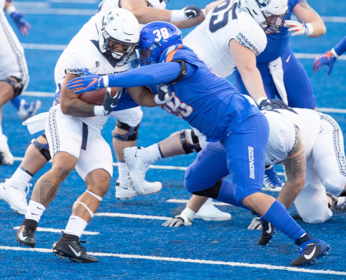 Boise State STUD Demitri Washington (38) tackles Utah State running back Jaylen Warren (20) during the game at Albertsons Stadium. Boise State defeated Utah State 42-13. Saturday October, 24, 2020.