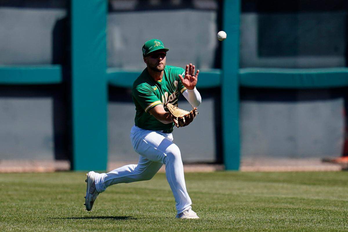 Oakland Athletics right fielder Seth Brown makes a running catch on a line drive hit by the Colorado Rockies’ Kris Bryant during the third inning of a spring training game April 2 in Mesa, Arizona.