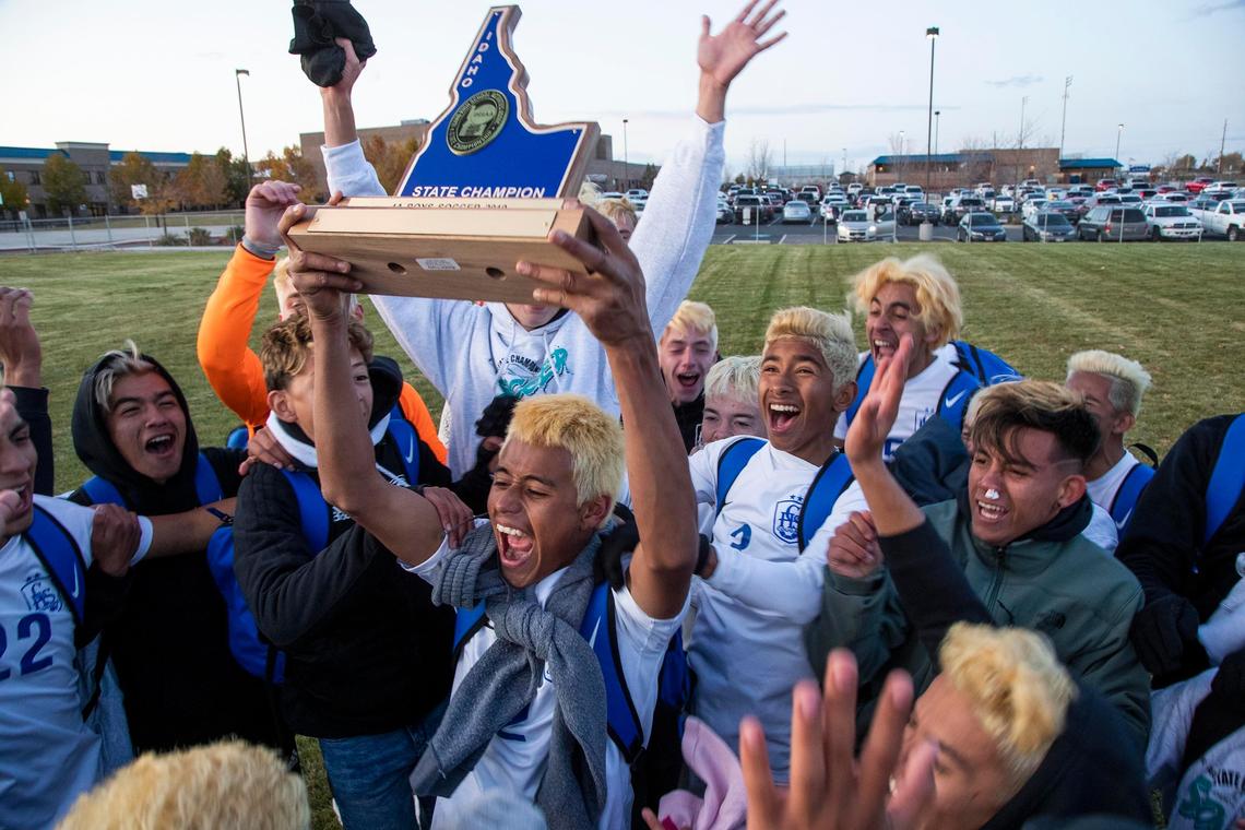 Caldwell’s Eric Lozano raises the 4A boys soccer state championship trophy after the Cougars won their second straight title in 2019.