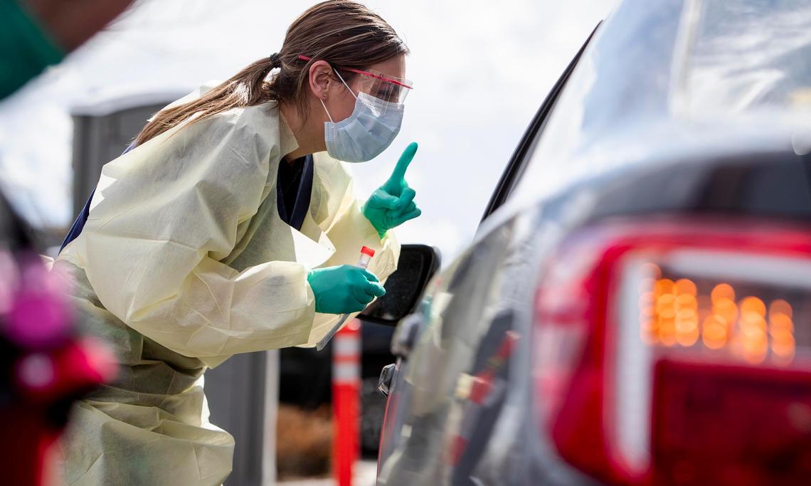 Ashley Layton, an LPN at St. Luke’s Meridian Medical Center, communicates with a person exhibiting symptoms before taking swab sample at a special outdoor drive-up screening station for coronavirus COVID-19 Tuesday, March 17, 2020. Several lanes were occupied Tuesday as screeners checked to see if people had actual symptoms or valid reasons to be tested.