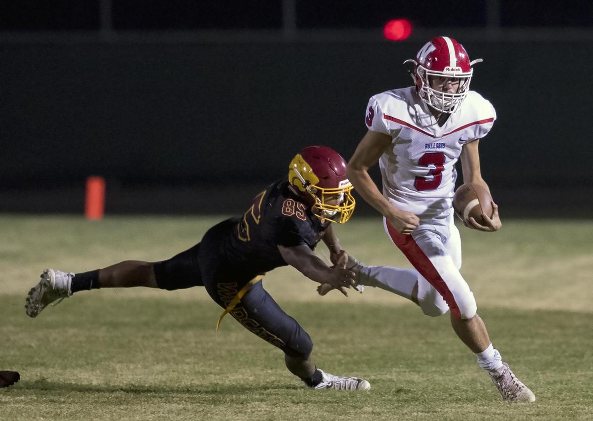 Nampa quarterback Braden Minor out runs Columbia’s Michael Cox last week during the Bulldogs’ fifth straight win.