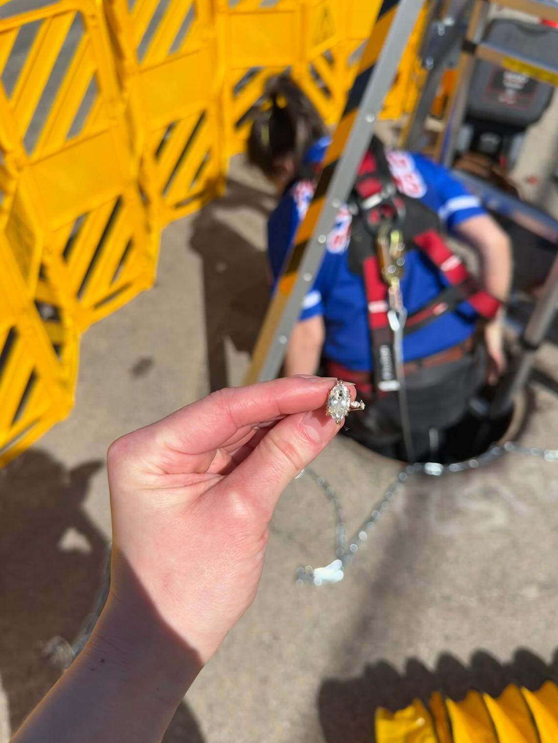 Dylan Arteaga climbs out of the manhole after finding Noelle Storey’s lost engagement ring.