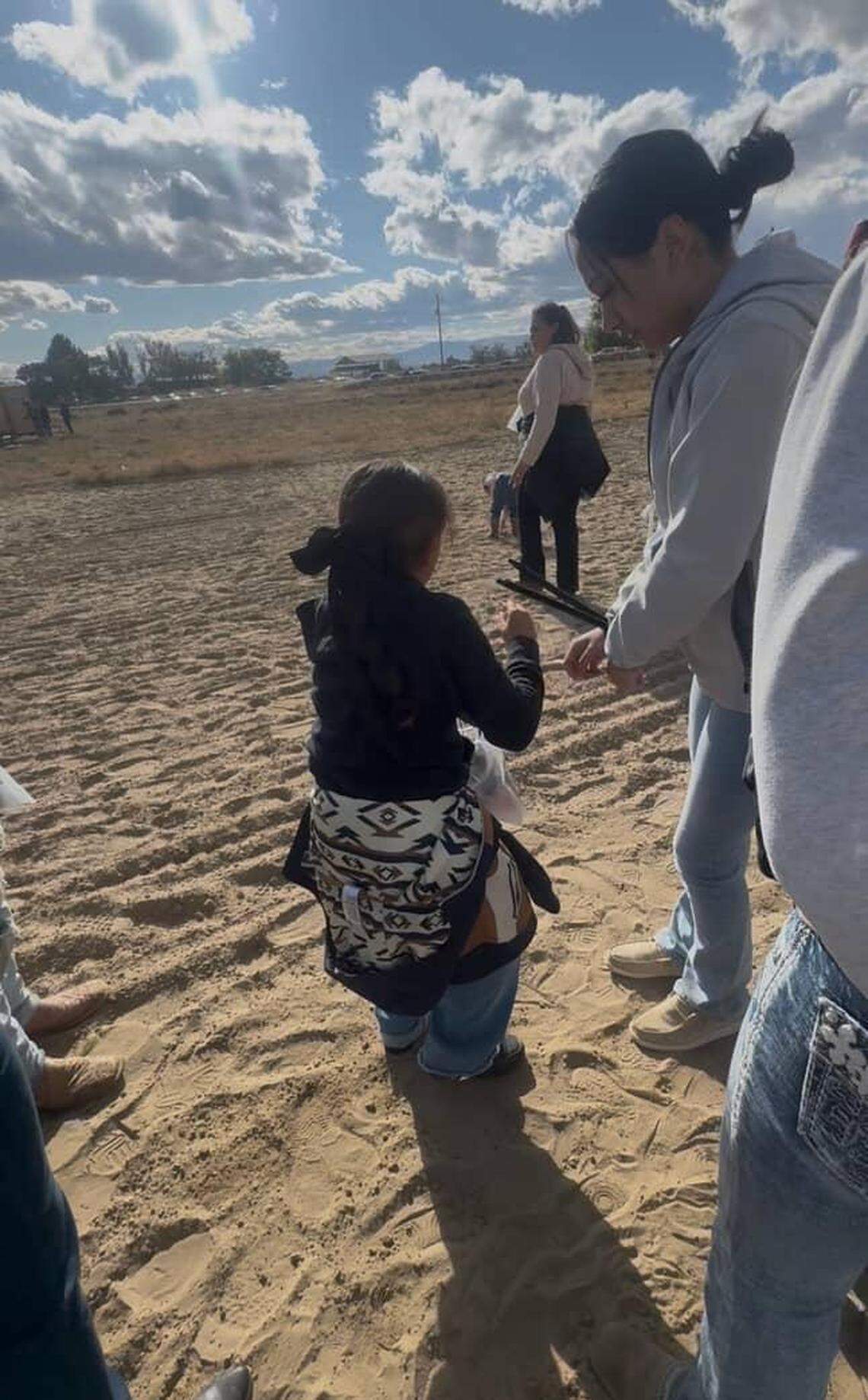 A photo shows SueHey Tello, 14, while she had zip-ties on her hands. She is standing next to her 8-year-old sister, NeVaeh Esparza, during the Wilder raid.