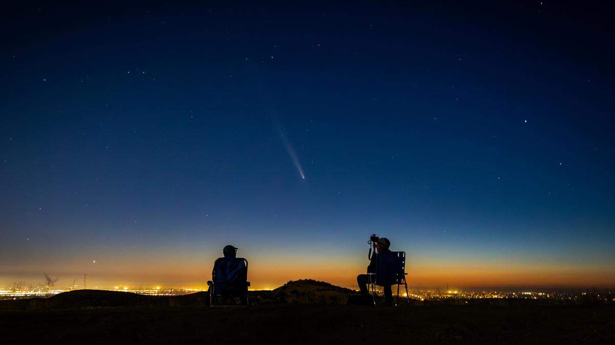 Comet C/2023 A3 (Tsuchinshan-ATLAS) makes an appearance in the western night sky as amateur photographers Nolan Letellier, left, and Link Jackson observe on a ridge near the Dry Creek Trailhead in Boise on Monday evening.