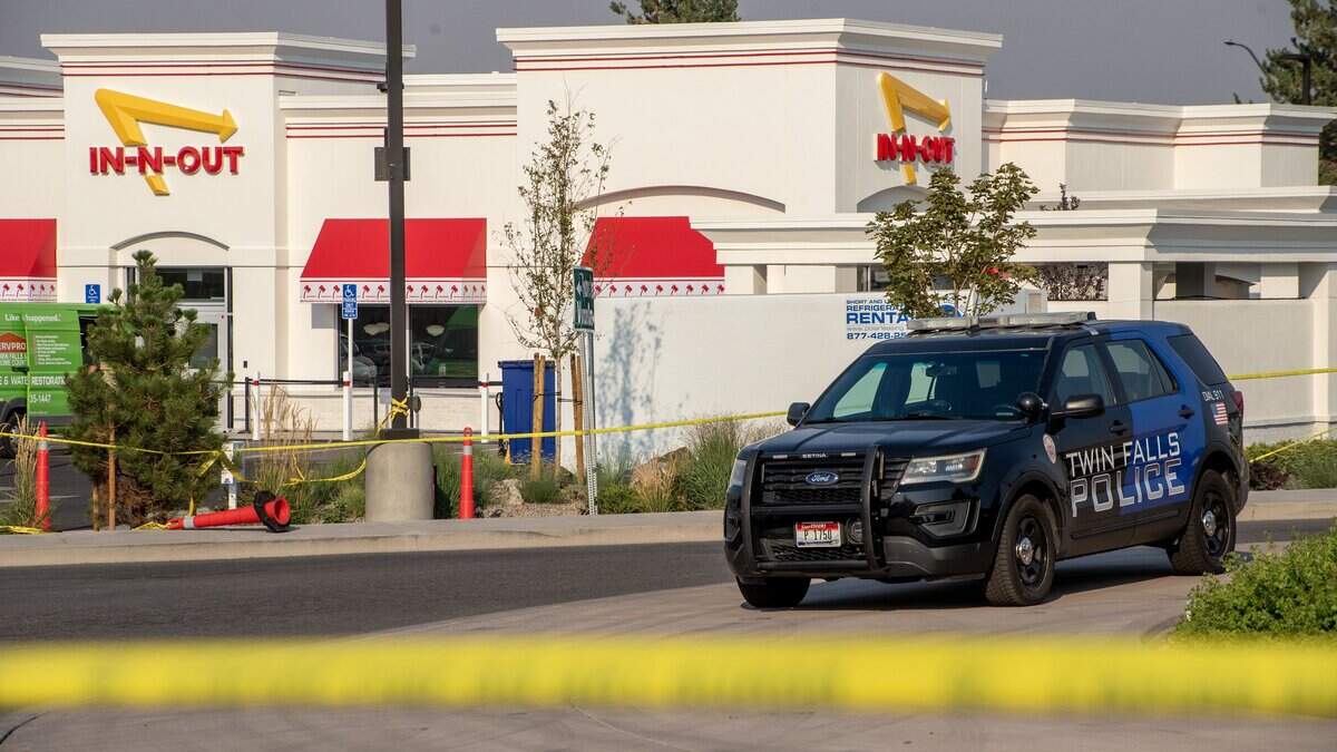 Twin Falls, Idaho, police officers secure the scene of Saturday’s mass shooting at an In-N-Out Burger as the investigation