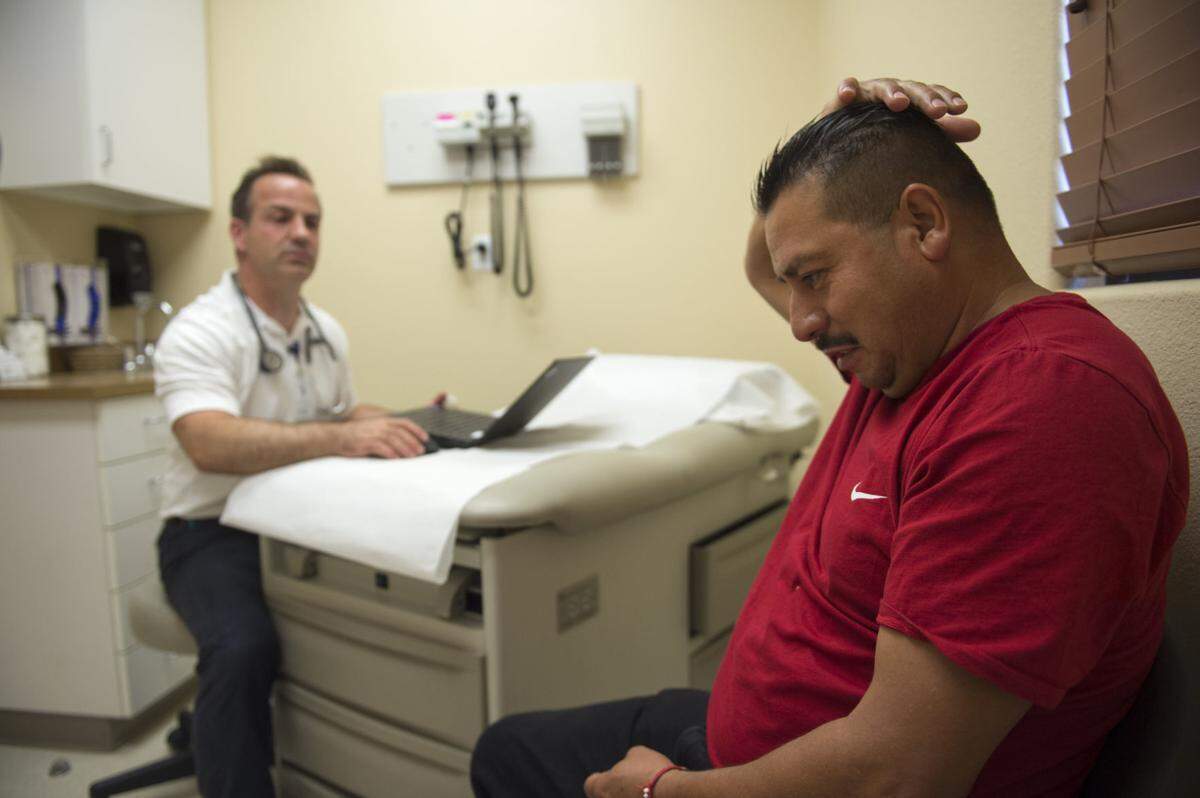 Melchor Avila Ocarranza, right, talks to physician assistant Todd Thorne July 19 at Family Health Services in Jerome.