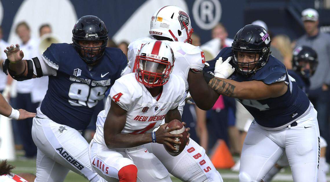 New Mexico quarterback Sheriron Jones (4) runs with the ball as Utah State’s Christopher Unga (96) and defensive end Fua Leilua (44) defend during an NCAA college football game, Saturday, Oct. 27, 2018, in Logan, Utah.