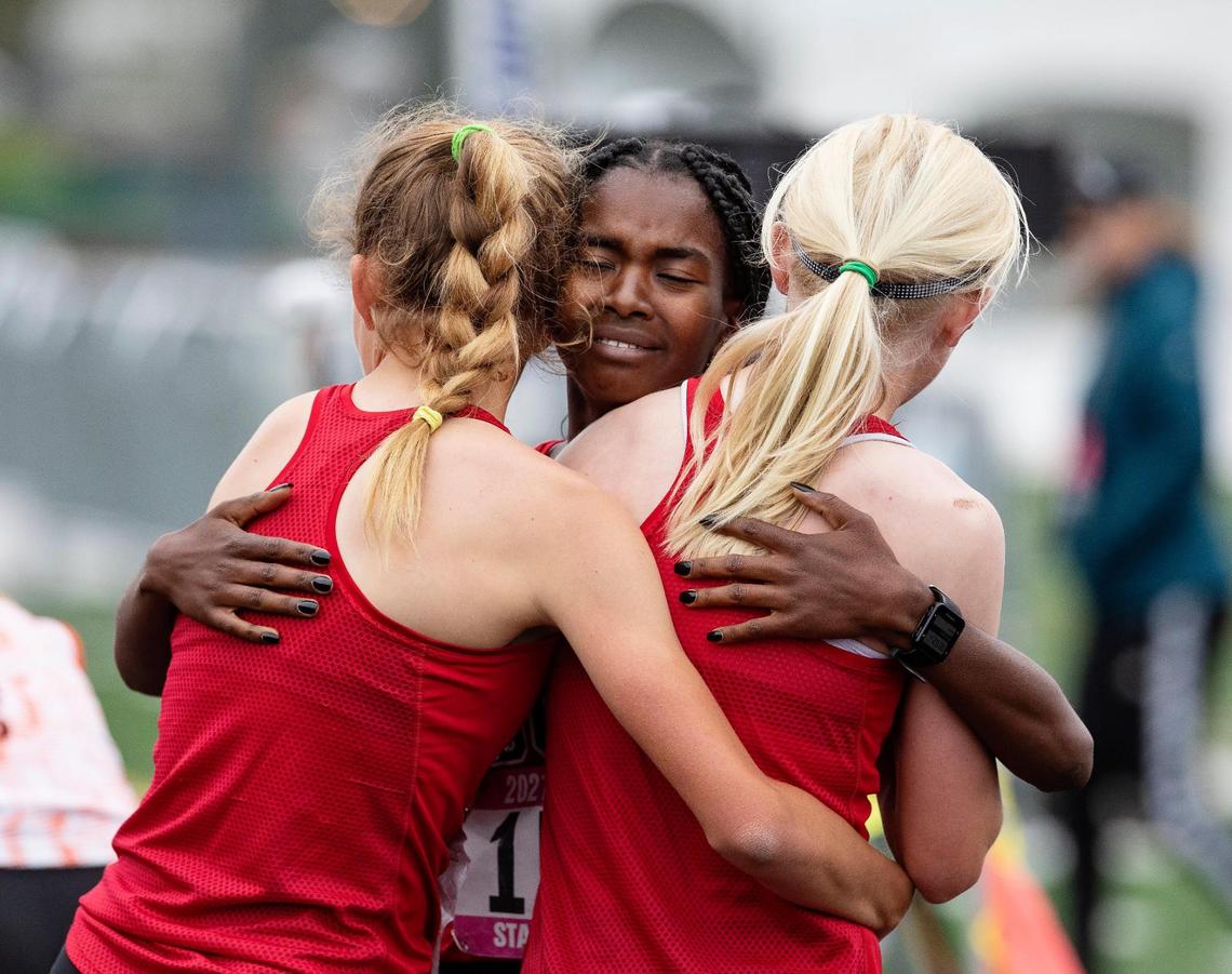 Boise High School’s Rosina Machu, center, hugs teammates Allie Bruce, left, and Sammy Smith, right, at the finish line of the 3,200 meters at the IHSSA track and field state championships at Eagle High School on Friday, May 21, 2021. Smith won the event. Bruce took second and Machu fourth.