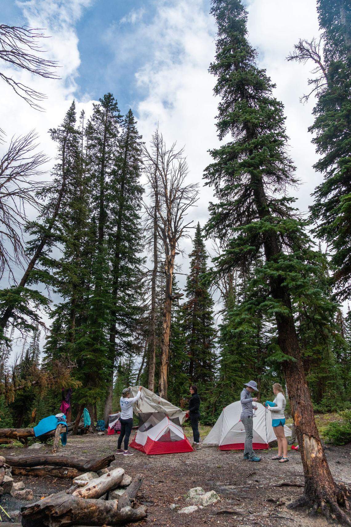 From right, Sydney Schoth, 18, and Maren Hunter converse while Tracy Perkins, 59, and Sarah Kirchner finish putting on a rain fly during an overnight backpacking trip with CSI’s Outdoor Recreation Center on Saturday, July 31, 2021, in the Salmon-Challis National Forest near Sun Valley.