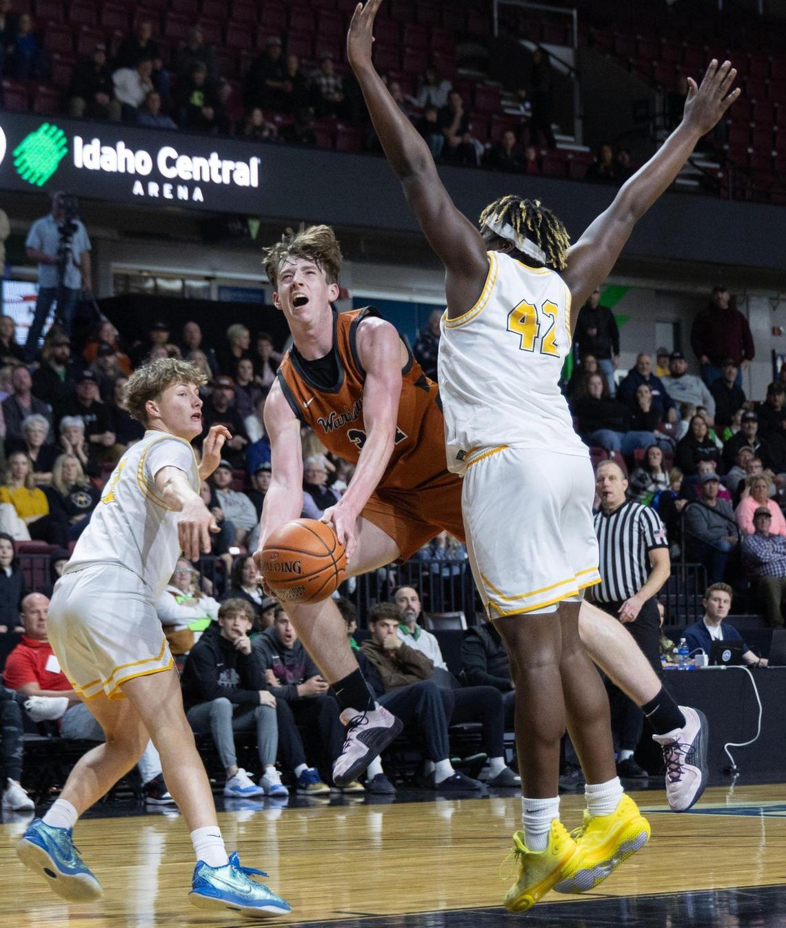 Ridgevue forward Tucker Tiddens drives to the hoop defended by Bishop Kelly’s Rakeem Johnson, right, in the 4A District Three boys basketball championship game Friday at Idaho Central Arena in Boise.