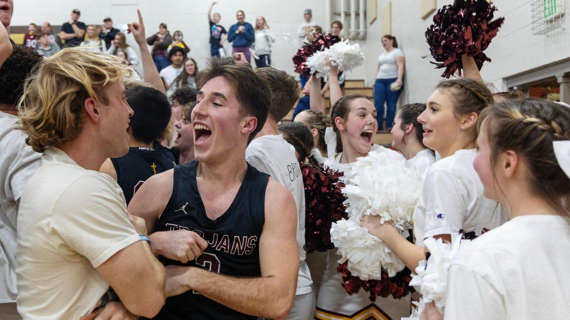 Nampa Christian senior Luke Lady, center, celebrates with fans after the Trojans beat Ambrose 49-41 in the 2A District Three Tournament championship Wednesday at Vallivue High for the Trojans’ first district title in 27 years.